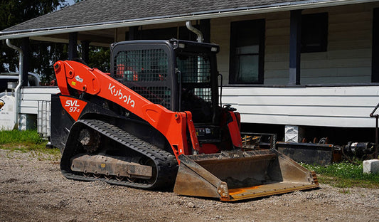 A red and black skid steer loader with rubber tracks, designed for compact track loader applications and track maintenance.