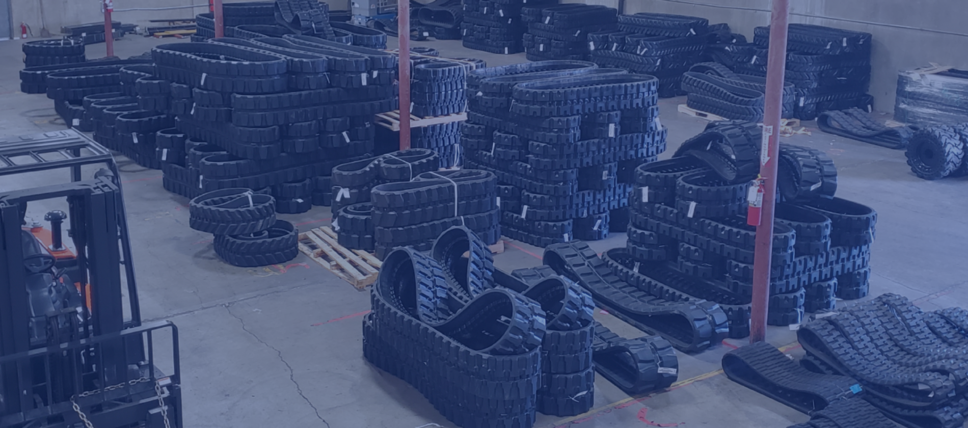 Warehouse showcasing high-quality rubber tracks and solid tires for heavy equipment
