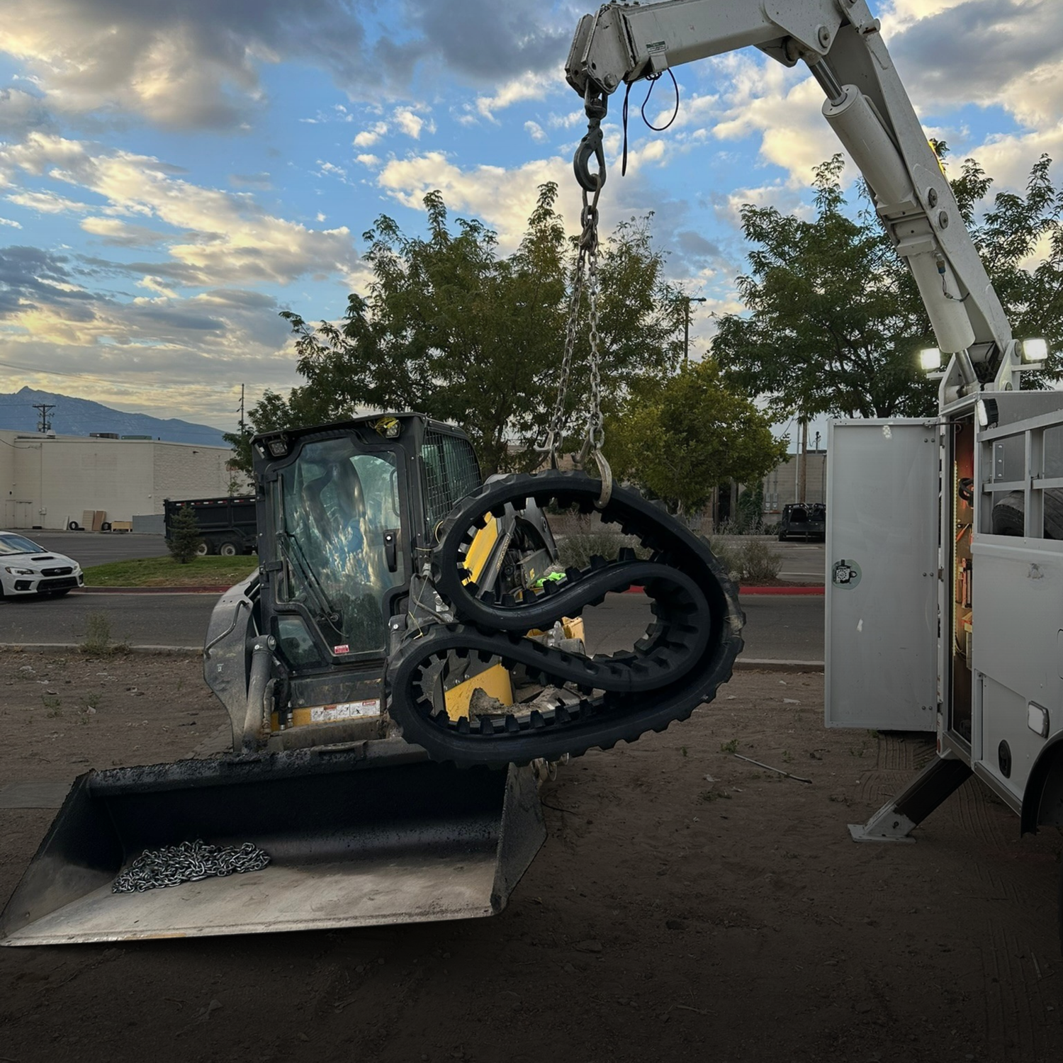 Mobile mechanic lifting rubber track with a crane, track installation on new holland track loader